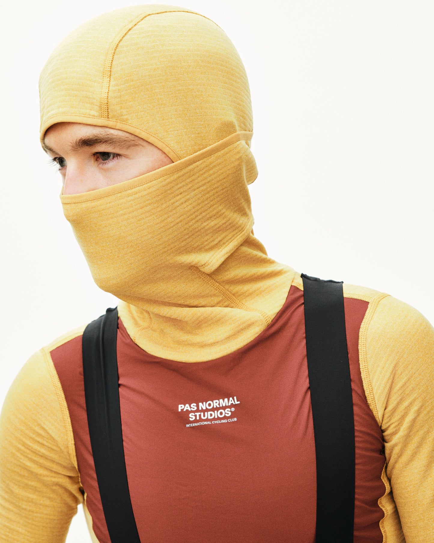 Person wearing a yellow balaclava and red shirt with 'PAS NORMAL STUDIOS' logo.