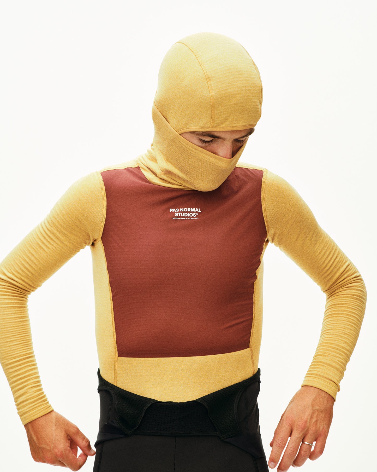 Person wearing a yellow and brown bodysuit with a hood on a white background
