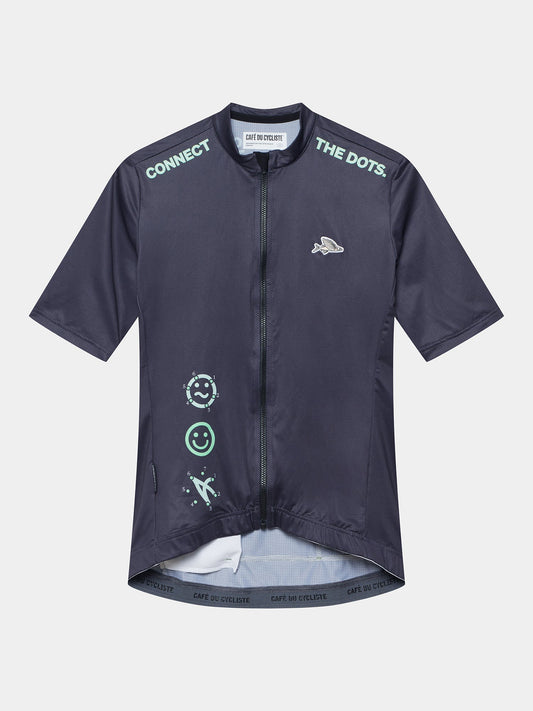 Women's navy cycling jersey with white and lighter grey dots pattern and text detail on the front.