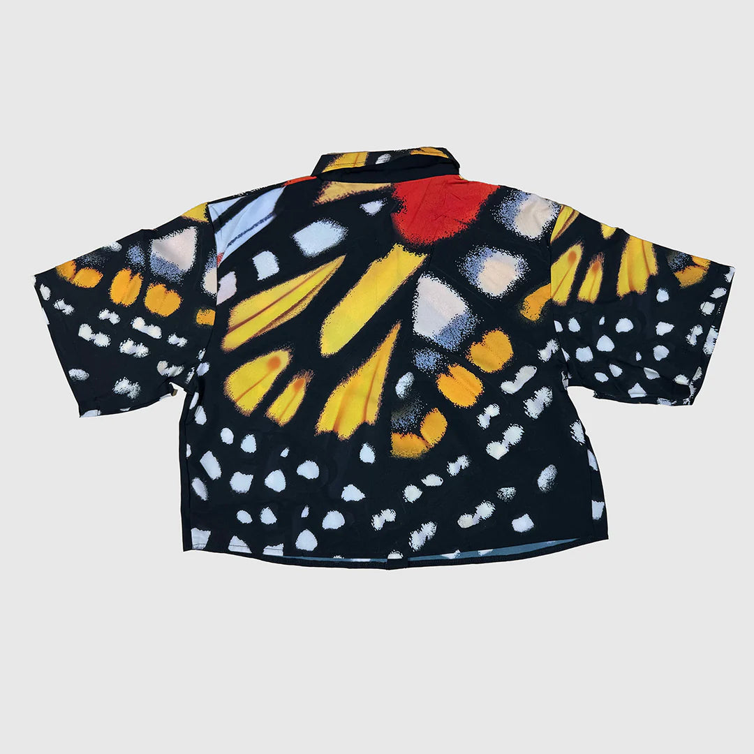Colorful butterfly-patterned shirt on a light gray background