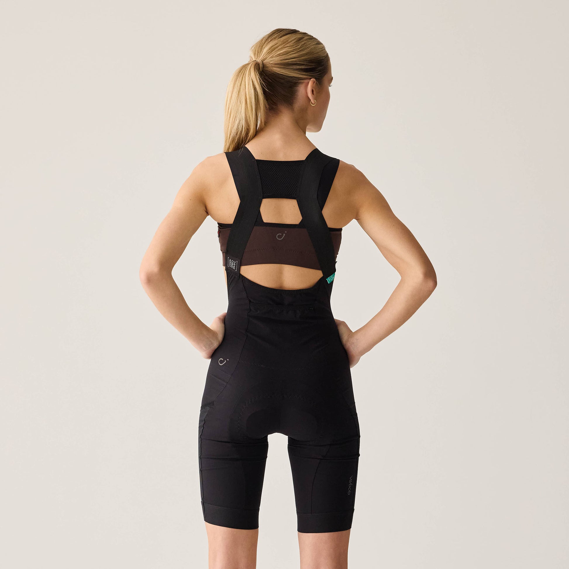 Adjustable shoulder straps and front bib panel of black women's adventure shorts.