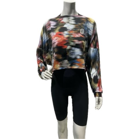 Mannequin wearing a colorful long-sleeve top and black leggings on a white background