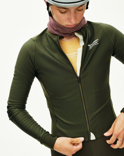 Person wearing a green athletic jacket with a visible brand logo on a white background