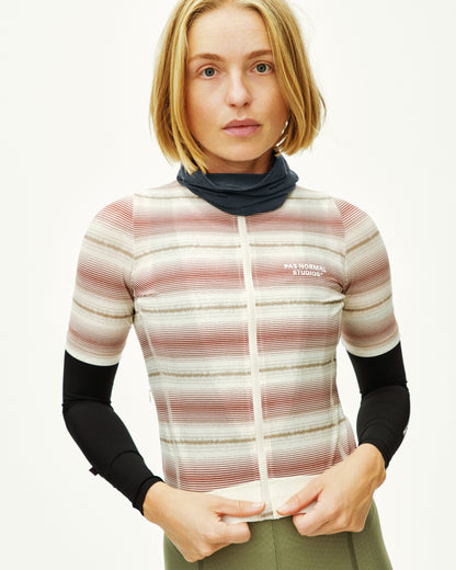 Woman wearing a striped jacket with a visible brand logo on a white background