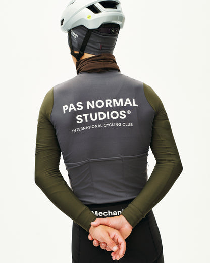 Person wearing a gray vest with 'PAS NORMAL STUDIOS' branding on a white background