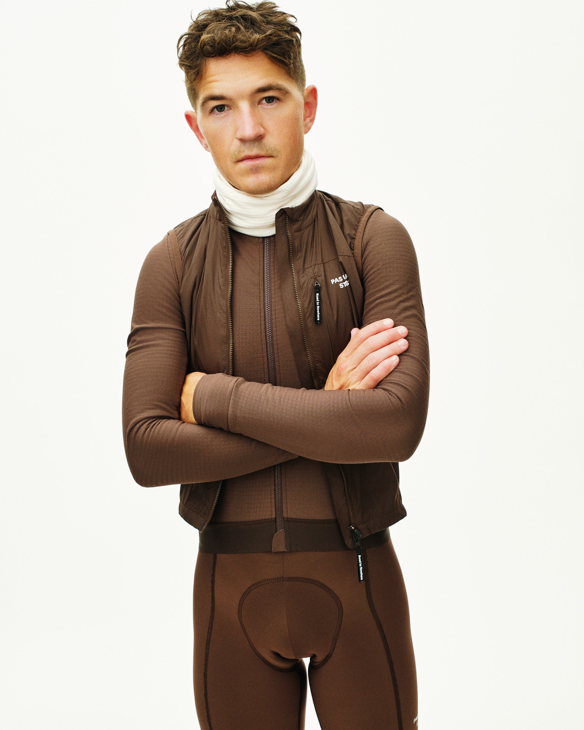 Man wearing a brown full-body suit with a white background