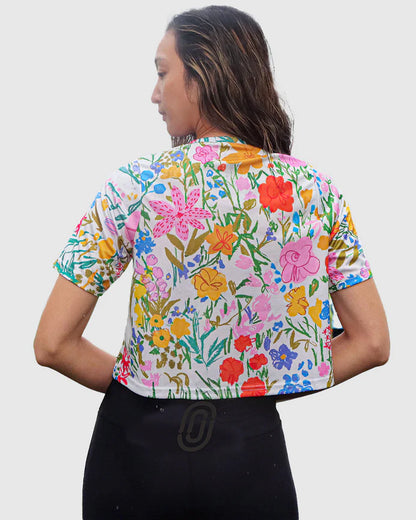 Woman wearing a colorful floral blouse against a white background
